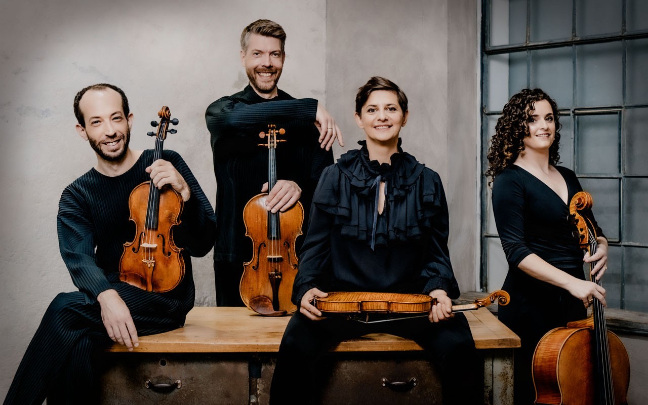 ccm-ariel-quartet-2025-01.jpg The Ariel Quartet poses in black clothing holding their instruments.