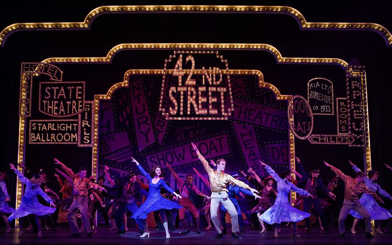 ccm-42nd-street-20191023-ml-01.jpg Large cast of student performers dance under lighted Broadway signs in a production of 42nd Street