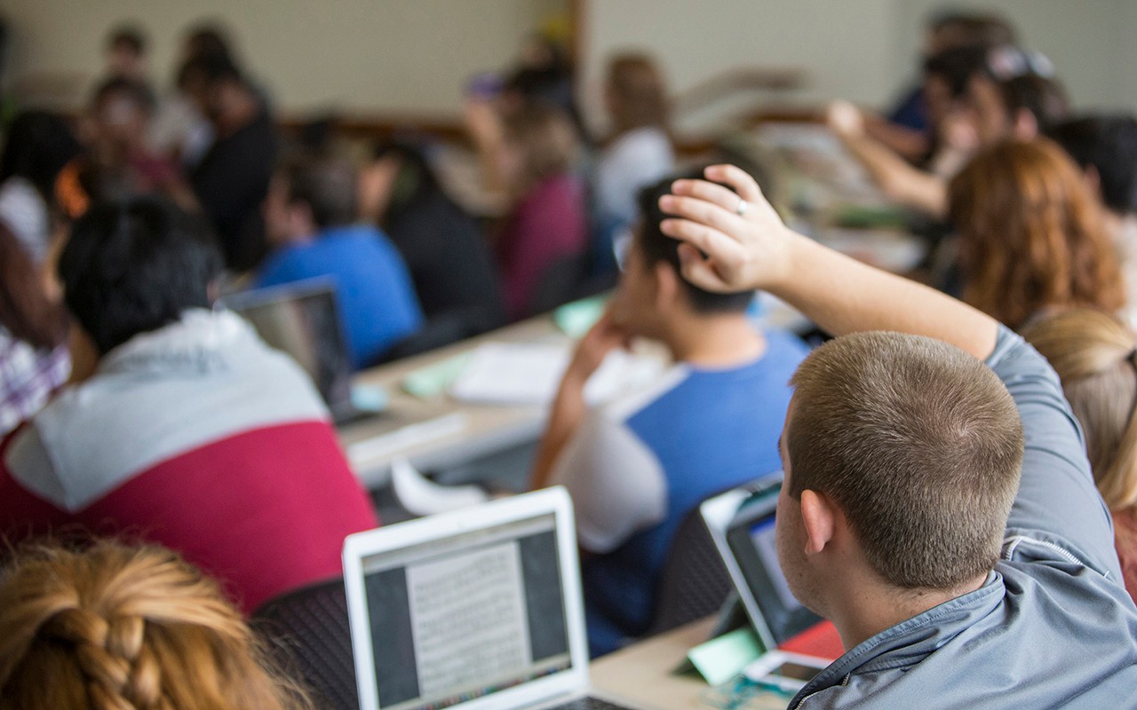 CCM student raises his during a class lecture